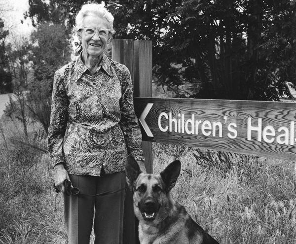 Woman with dog by sign outdoors